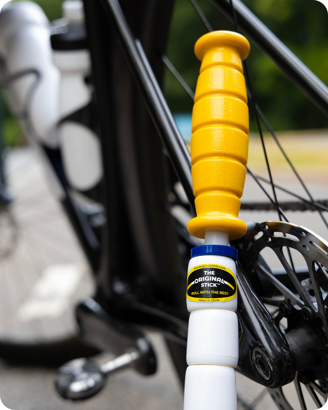 Marathon Stick leaning next a bike wheel which is blurred in the background.