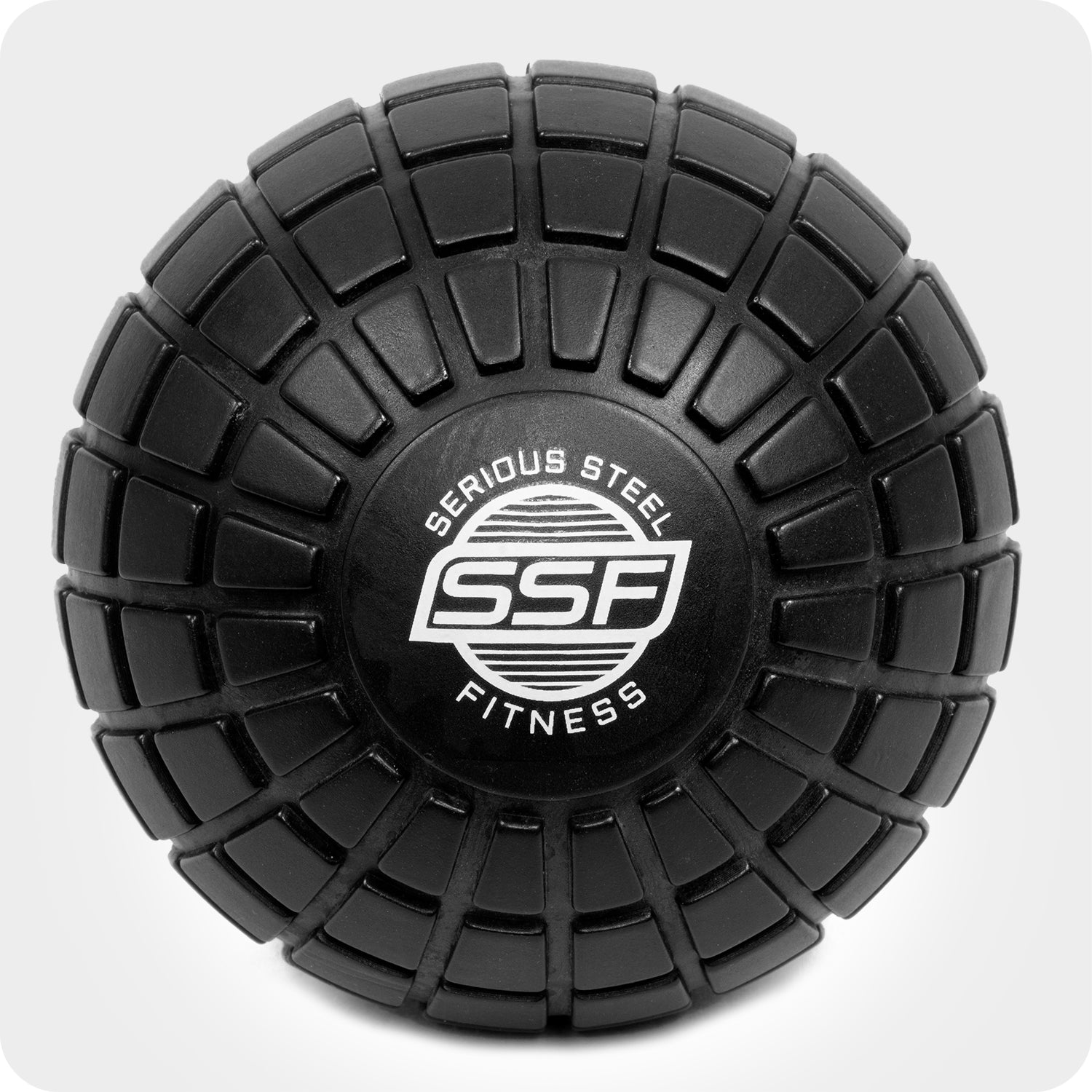 The 5 Massage Ball is black with a textured grid pattern and a white Serious Steel Fitness (SSF) logo at the center, shown from above against a light background.
