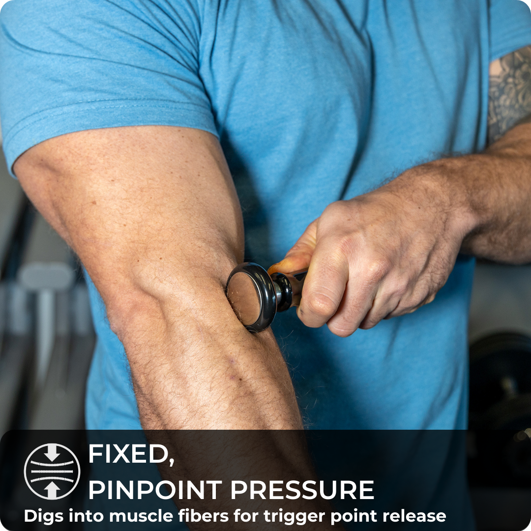 A person in a blue shirt uses The Intruder™ handheld massage tool on their forearm. A text overlay reads: FIXED, PINPOINT PRESSURE – Digs into muscle fibers for effective trigger point therapy and relief.