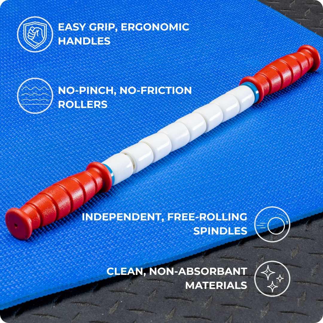 The Travel Stick-18, a red and white massage roller, sits on a blue mat, featuring ergonomic easy-grip handles, no-pinch free-rolling spindles, and clean non-absorbent materials—a gym bag must-have for muscle recovery.